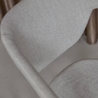 Tonka FR recycled-content FR upholstery fabric in interior — both fibres recycled, salt-and-pepper texture. Lifestyle view 1.