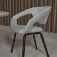 Tonka FR recycled-content FR upholstery fabric in interior — both fibres recycled, salt-and-pepper texture. Lifestyle view 3.