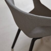 Tonka FR recycled-content FR upholstery fabric in interior — both fibres recycled, salt-and-pepper texture. Lifestyle view 4.